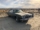 A sedan parked at a deserted area under a cloudy sky
